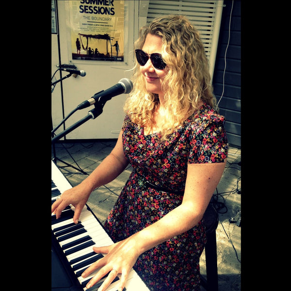 Charlotte Kerrigan playing keyboard live and singing