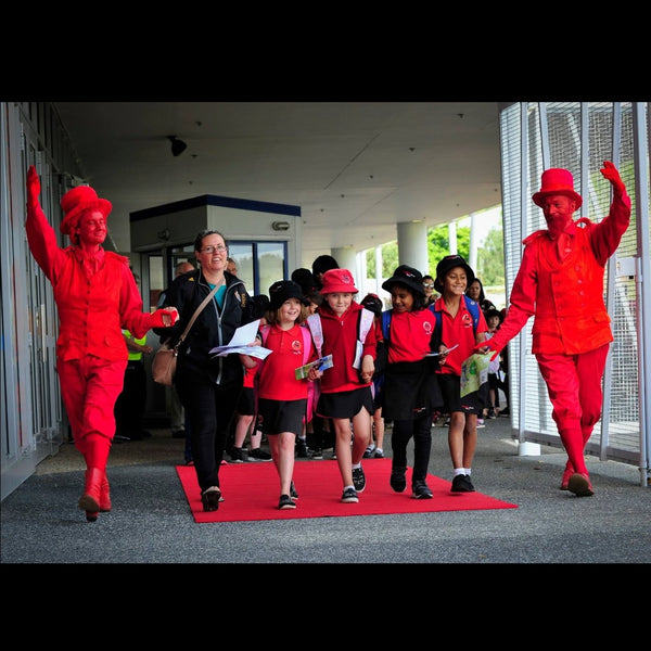 Free Lunch strolling characters in red leading children in to an event