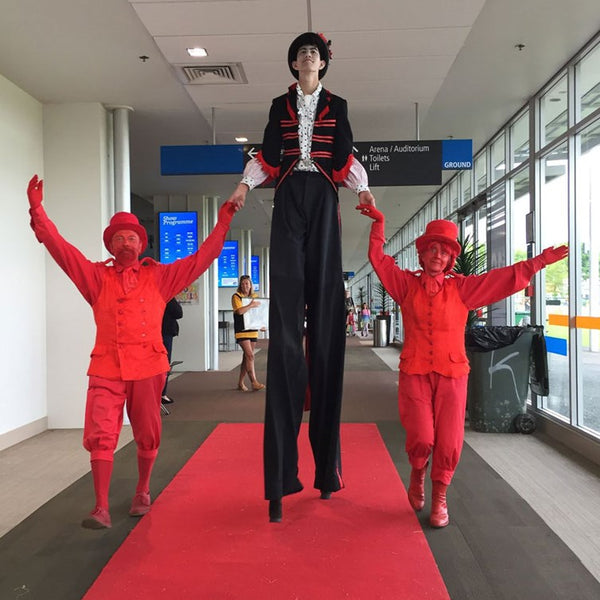 Free Lunch Hamilton red characters and stilt walker