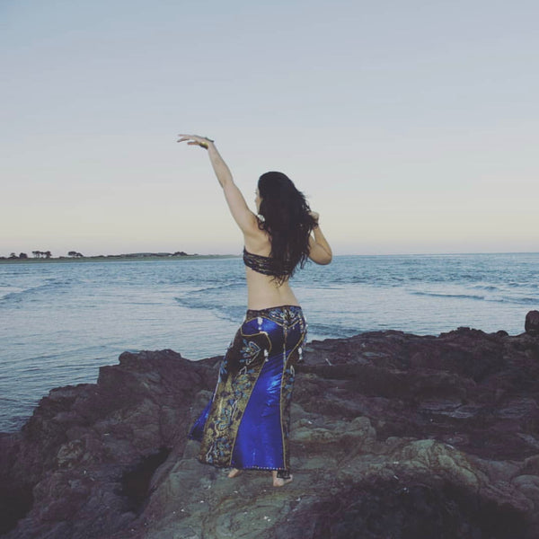 Christchurch belly dancer Hannah on the rocks beside the sea Christchurch